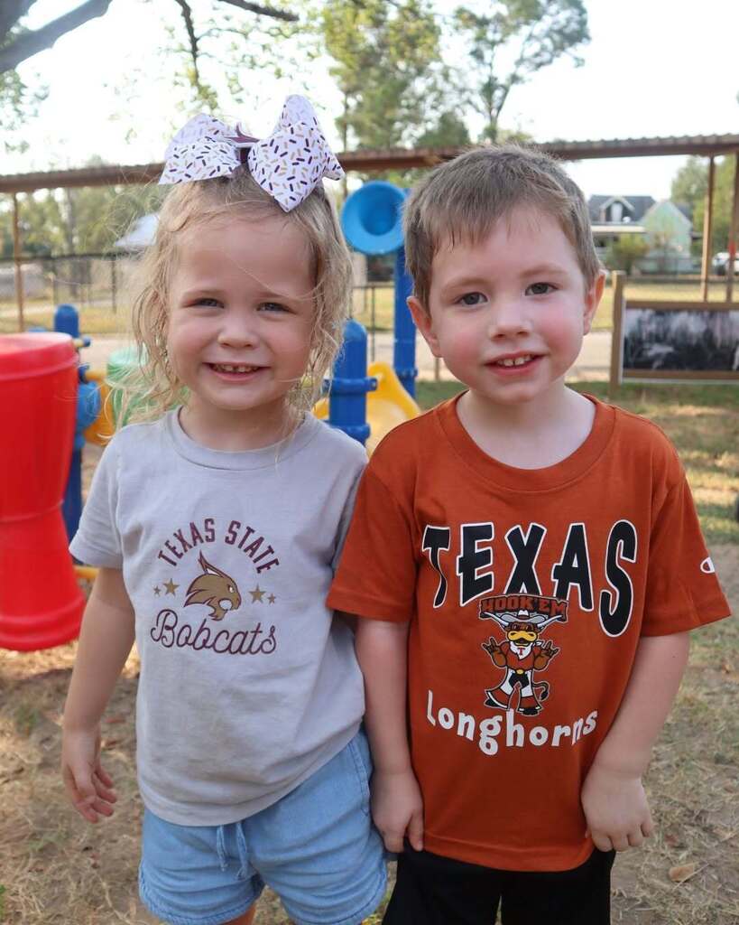 Two children standing together and smiling.