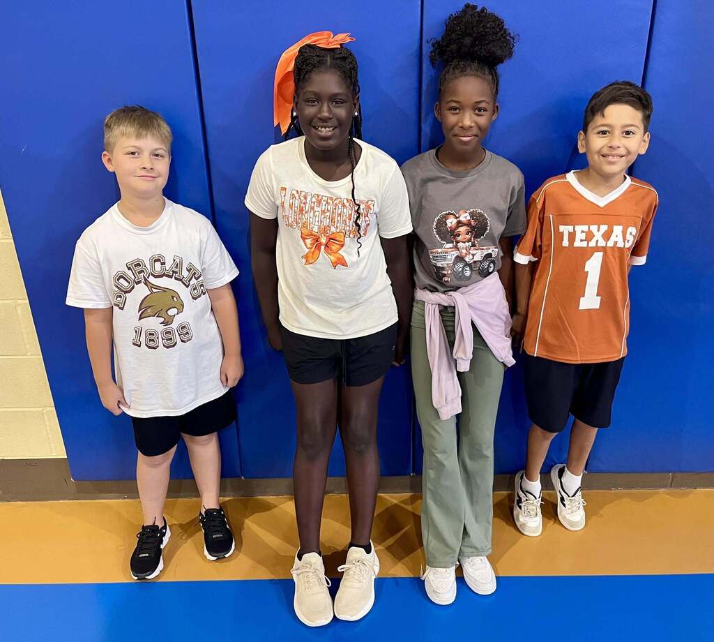 Four students standing together and smiling