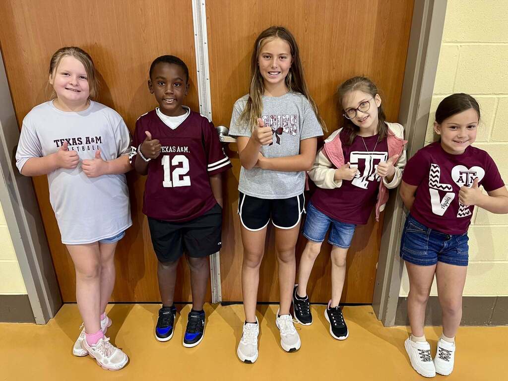 5 students standing together and smiling