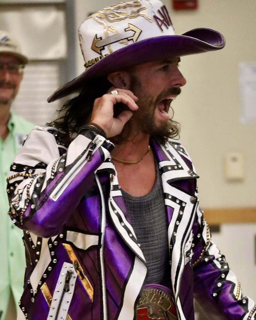 Man in purple jacket and cowboy hat