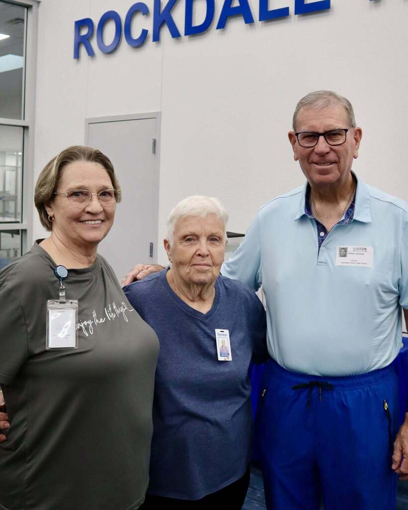 Three people standing together and smiling