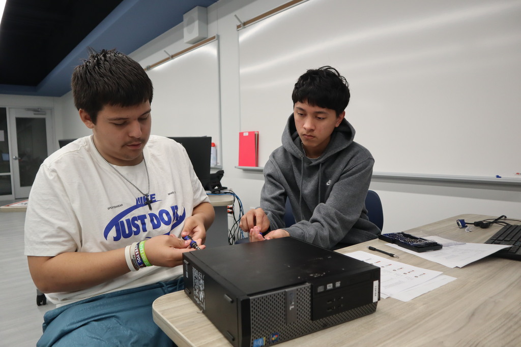 Two students working on a computer monitor