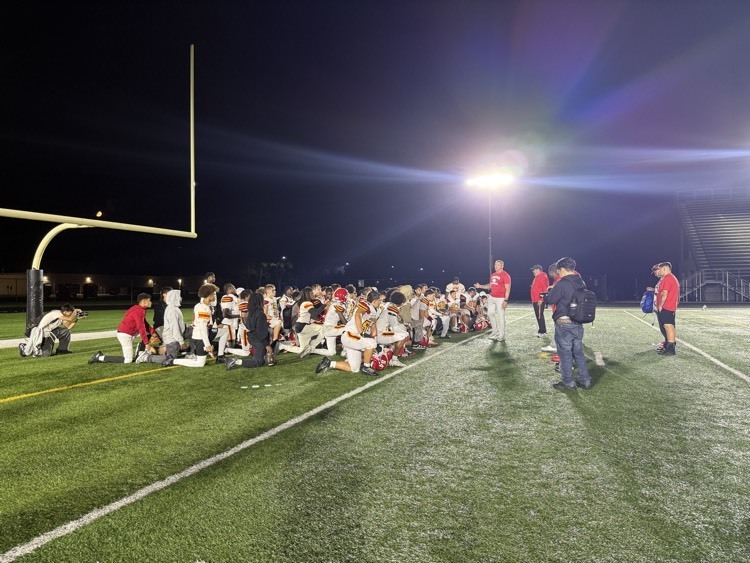 Jefferson football gathers in the end zone for a post game coaches talk