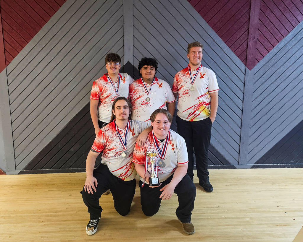 Jefferson High School boys varsity bowling team poses together on the bowling lanes after earning 4th place at the Season Kickoff Invitational. The five players wear matching white jerseys with red and gold designs and medals around their necks, with one player holding the team’s trophy.