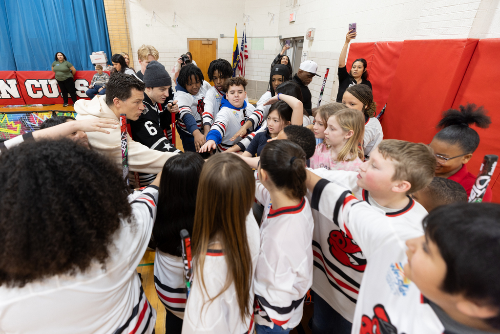 Hockey pros and Conklin students in huddle