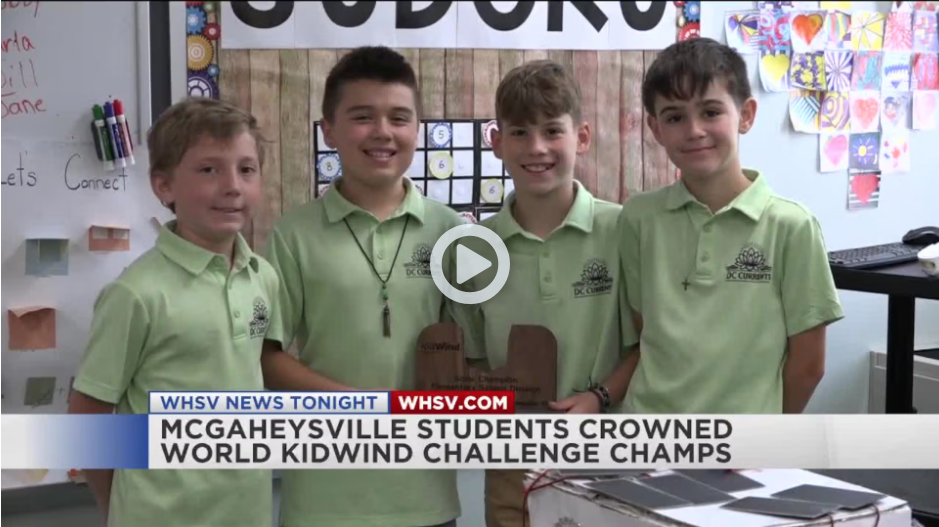 4 boys standing in a classroom holding a wooden trophy all boys wearing a pale green shirt