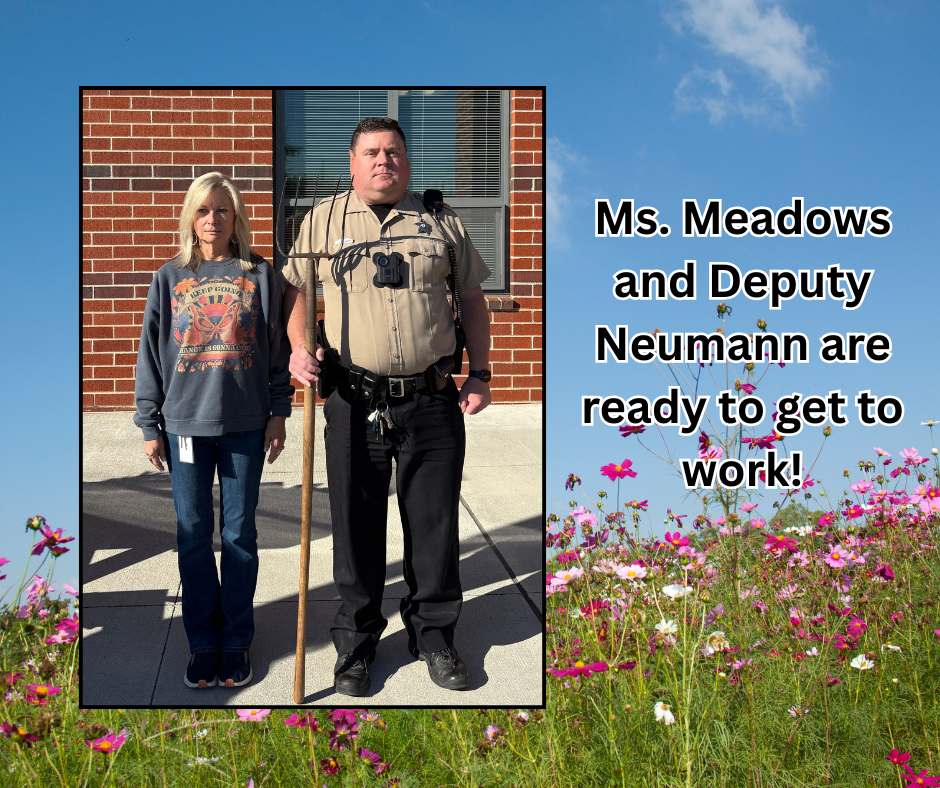 Two people stand outside a brick building with flowers. One holds a cane, the other wears a police uniform. Text reads, "Ms. Meadows and Deputy Neumann are ready to get to work."