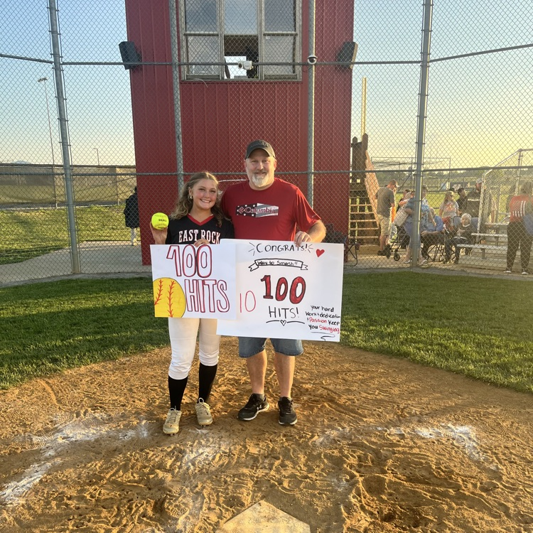 Bre Malin is pictured with her father holding the ball for her 100th career hit. 