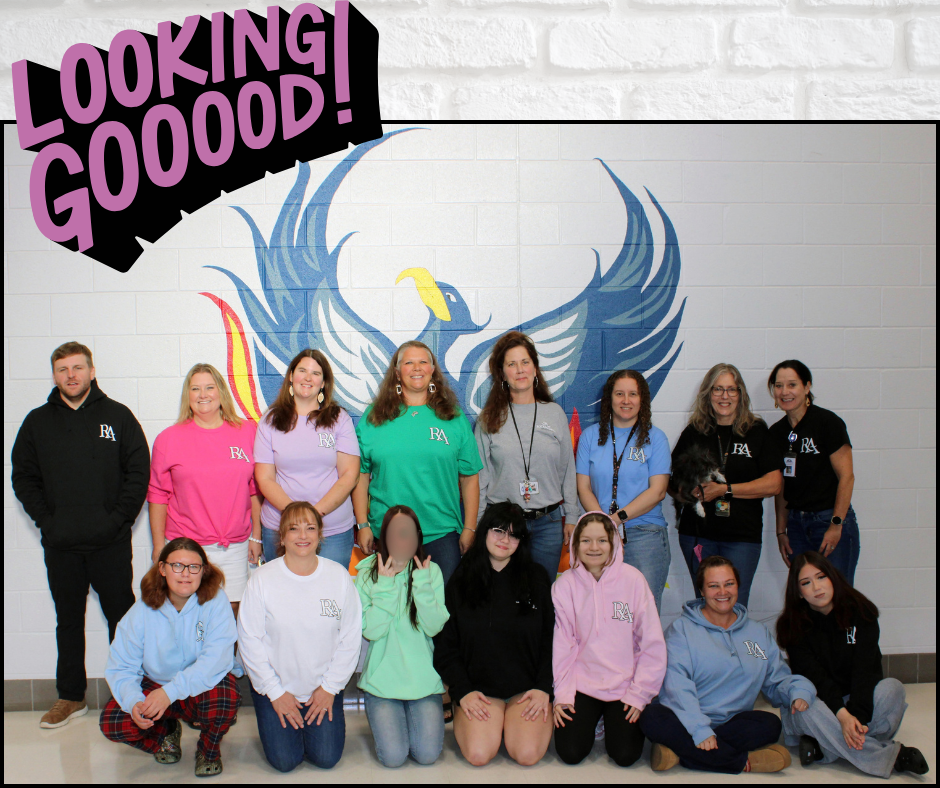 Group of individuals standing and sitting in front of a wall with a blue bird design.