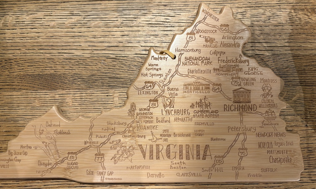 A wooden map of Virginia with city names and road details displayed on a wooden surface.