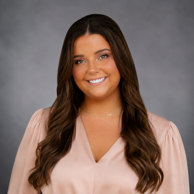 Ms. Liskey is pictured in a professional photo where a rose colored shirt. 
