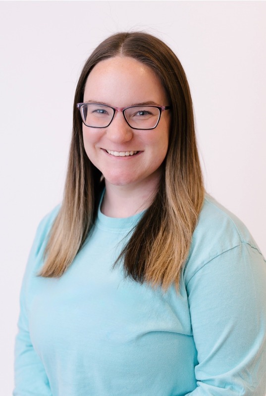 Mrs. Shank is pictured wearing a light blue shirt in a professional picture  with a white background