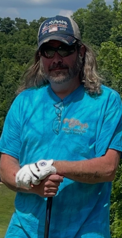 Mr. Payne is pictured wearing a blue shirt and baseball cap holding a golf club.