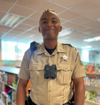 Deputy Smith is pictured in a library wearing his police uniform. 