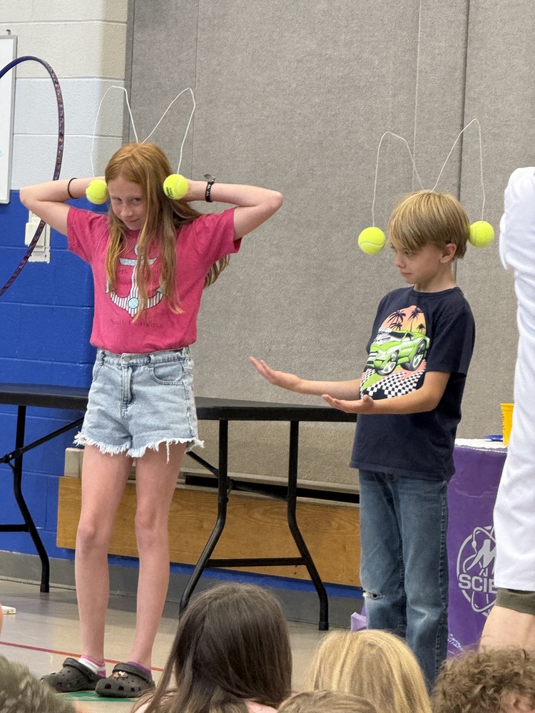 students balancing tennis balls on head 