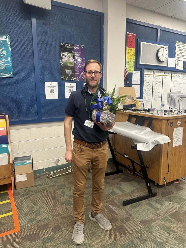 RMS Teacher of the year holding flowers in room 