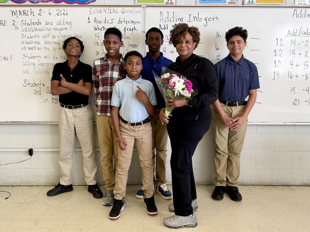 Teacher holding flowers with students