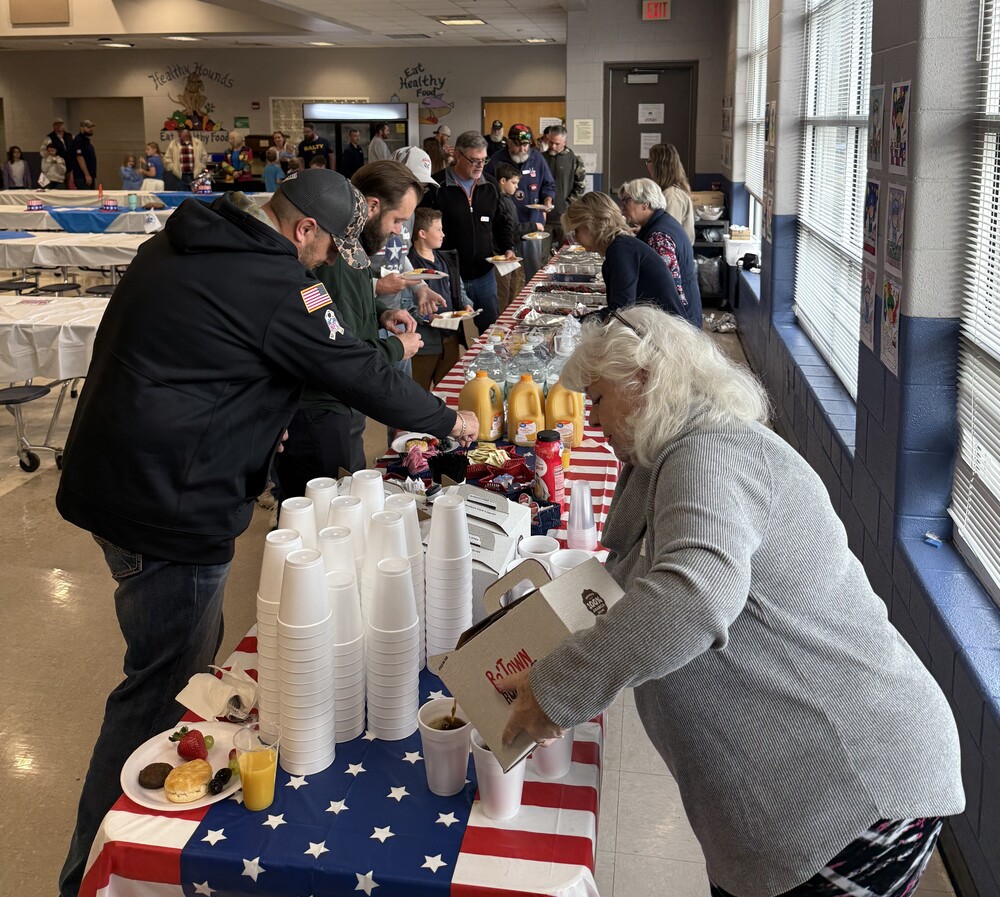 adults leaning over table selecting food