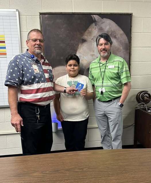 Student with teacher and principal holding gift card