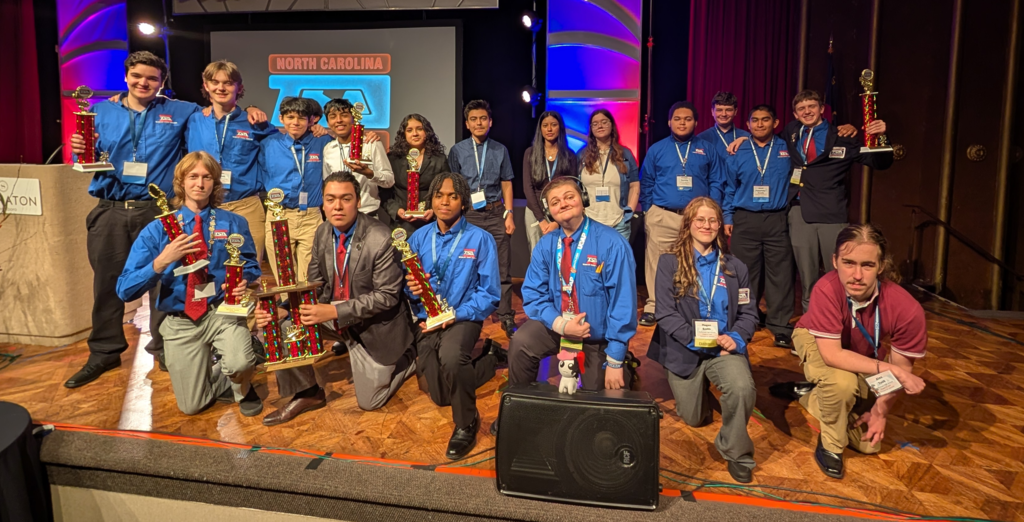 students on stage some holding trophies