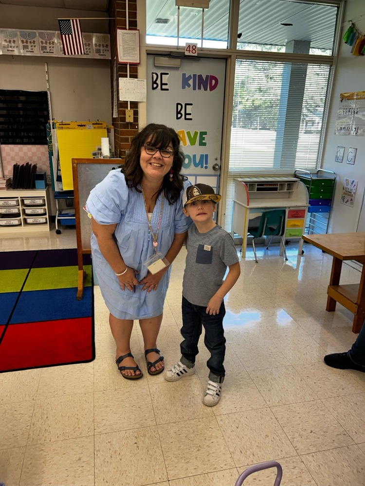 first grade teacher takes a photo with her new student