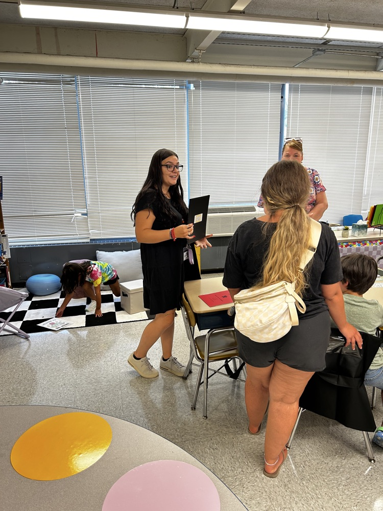 teacher talks with parents in classroom