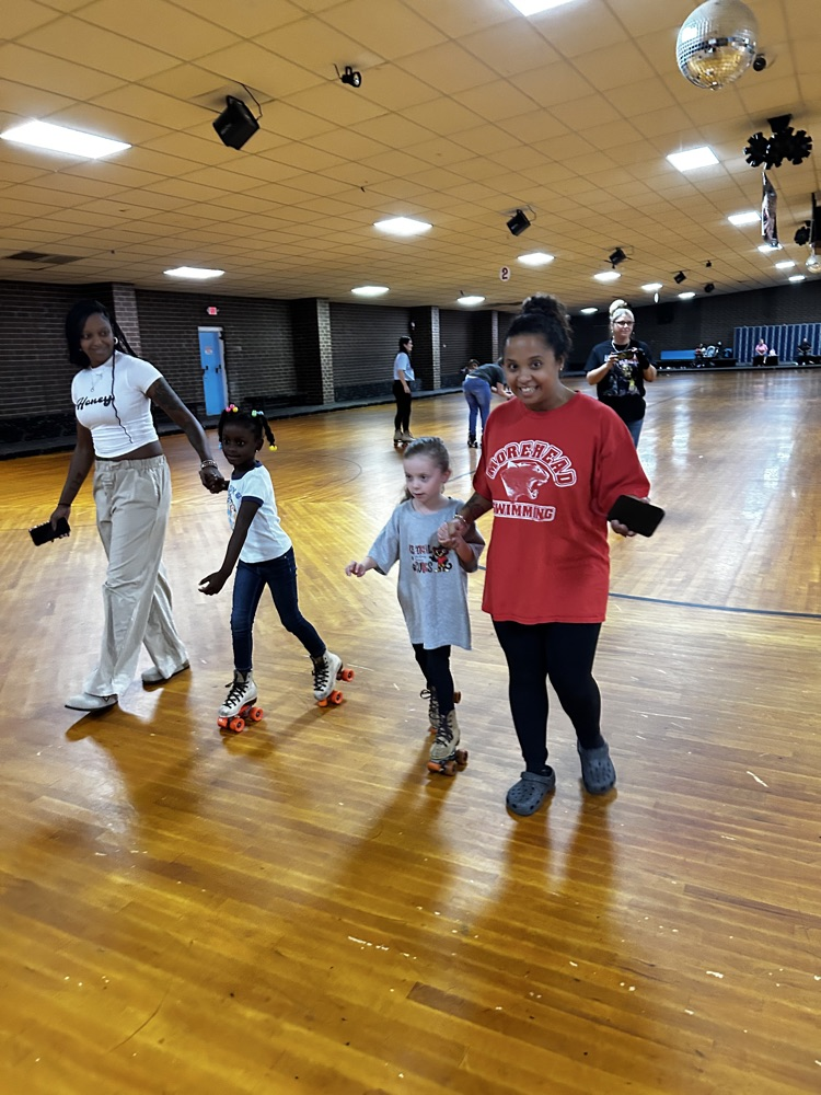 two adults and two students skate together 
