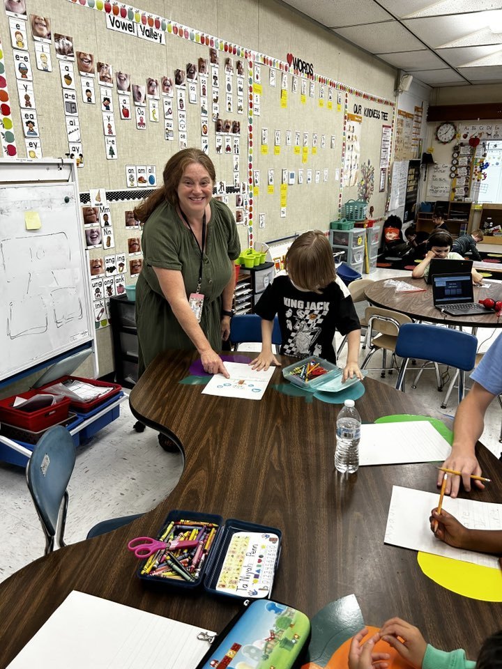 teacher helps student with worksheet