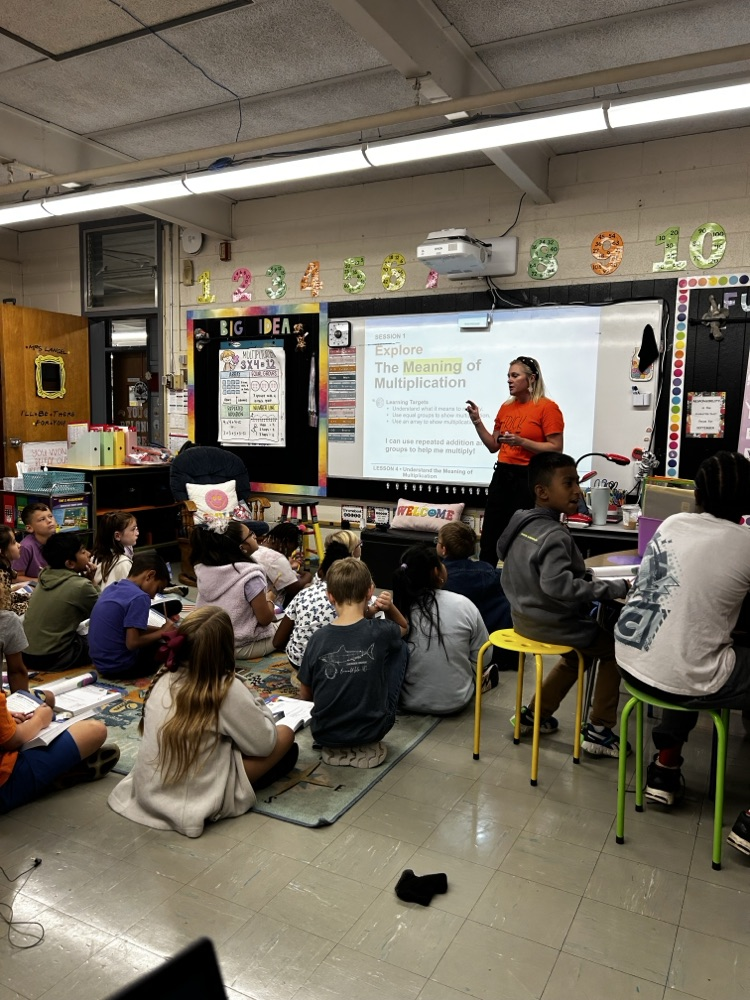 teacher instructs students from front of classroom