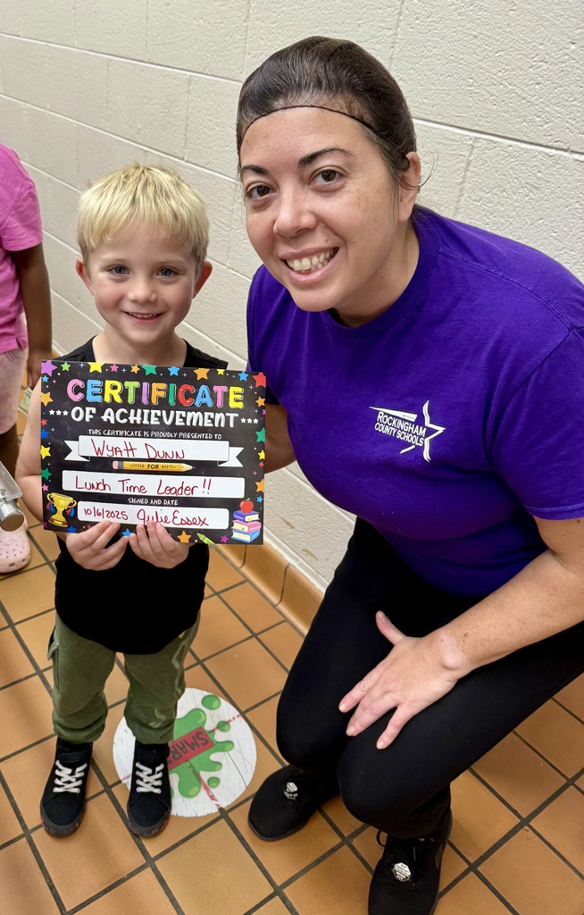 Lunch leader of the month stands with his certificate and the cafeteria manager