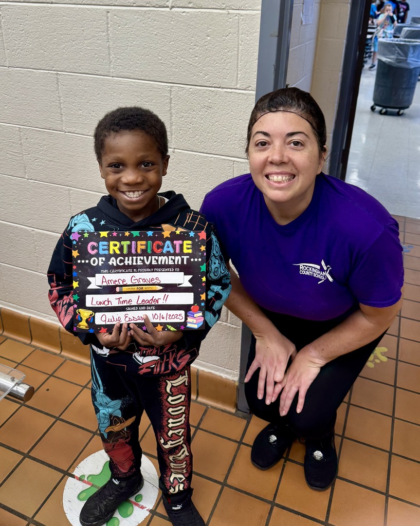 Lunch leader of the month stands with his certificate and the cafeteria manager
