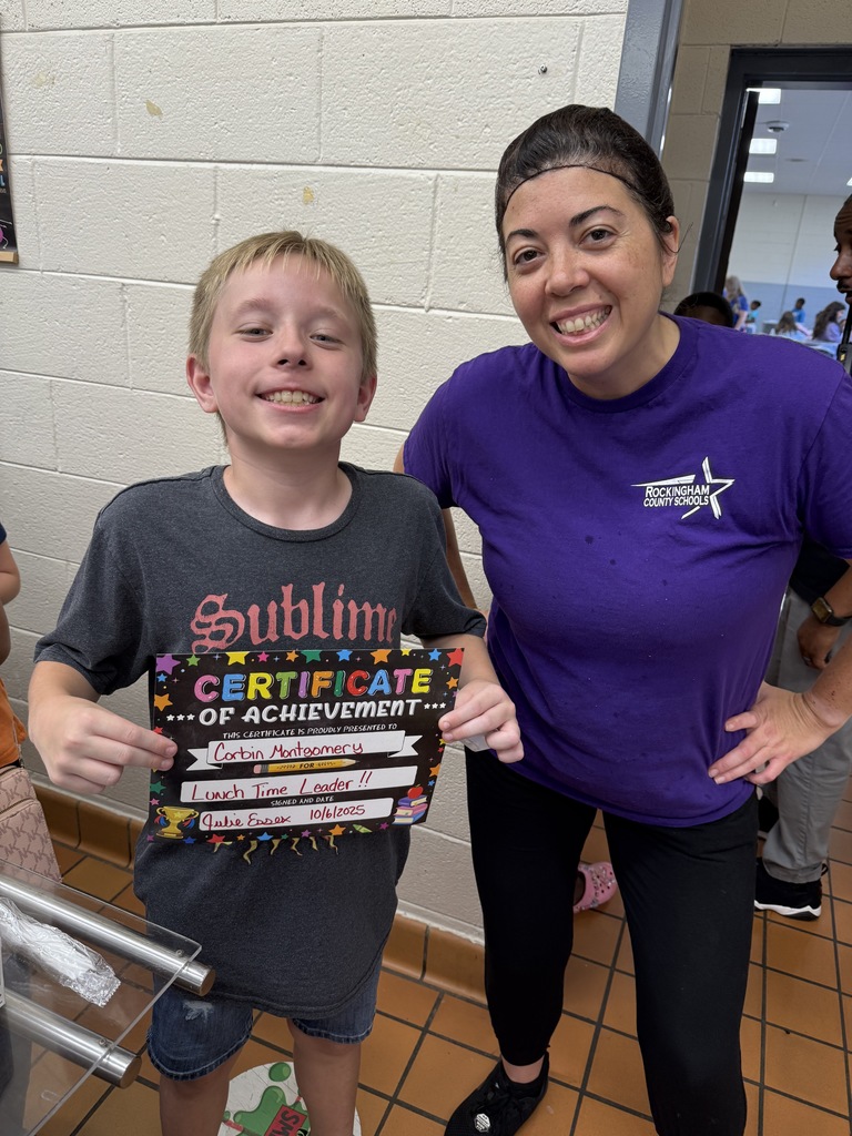 Lunch leader of the month stands with his certificate and the cafeteria manager