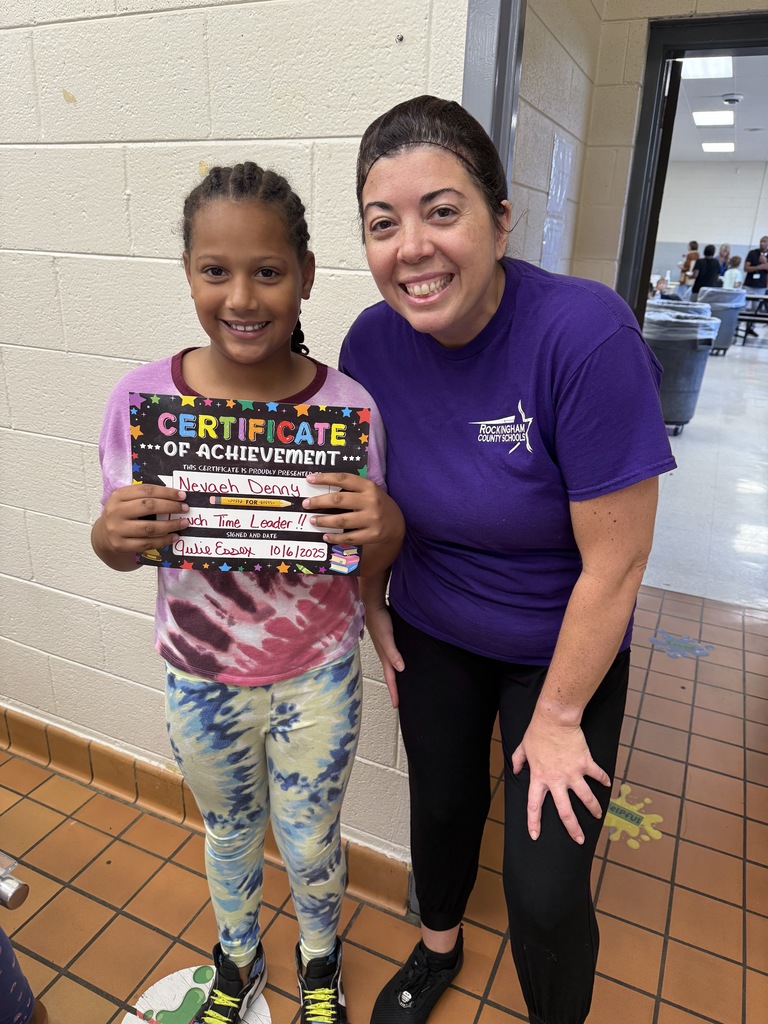 Lunch leader of the month stands with her certificate and the cafeteria manager