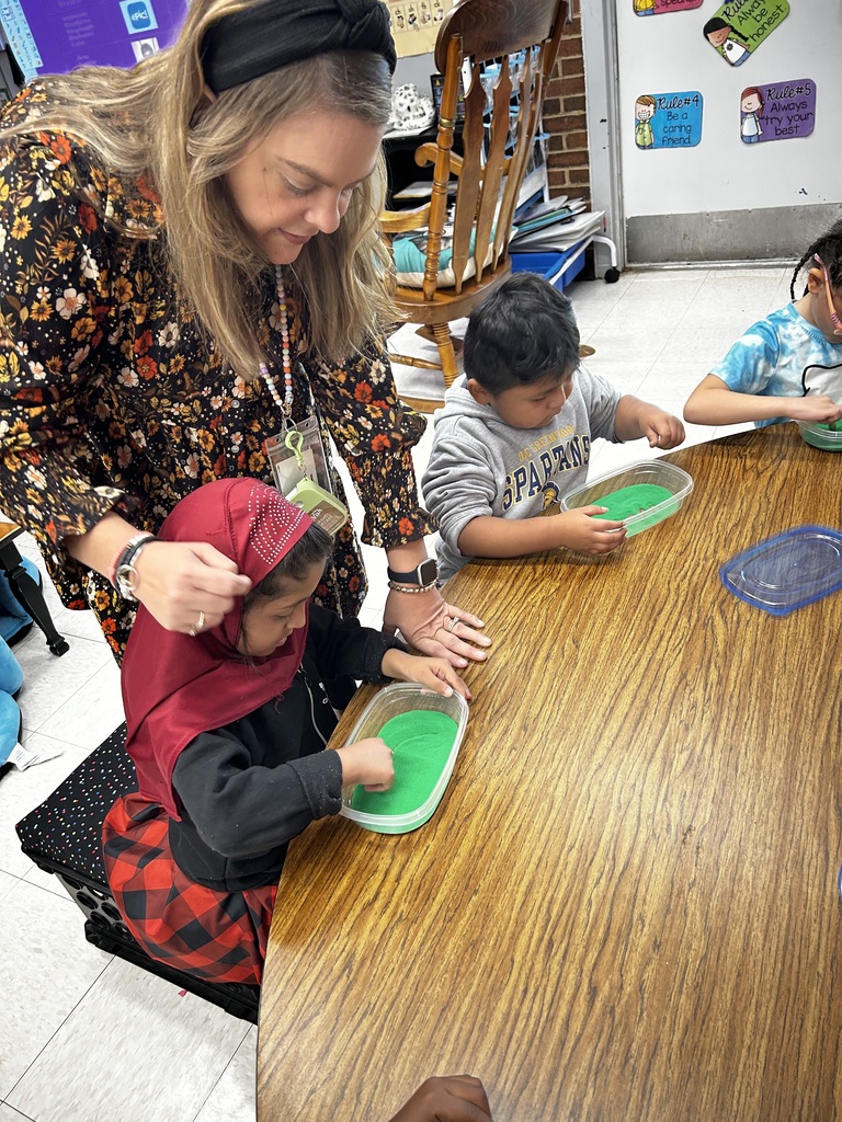 Teacher works with student as she makes her own slime.