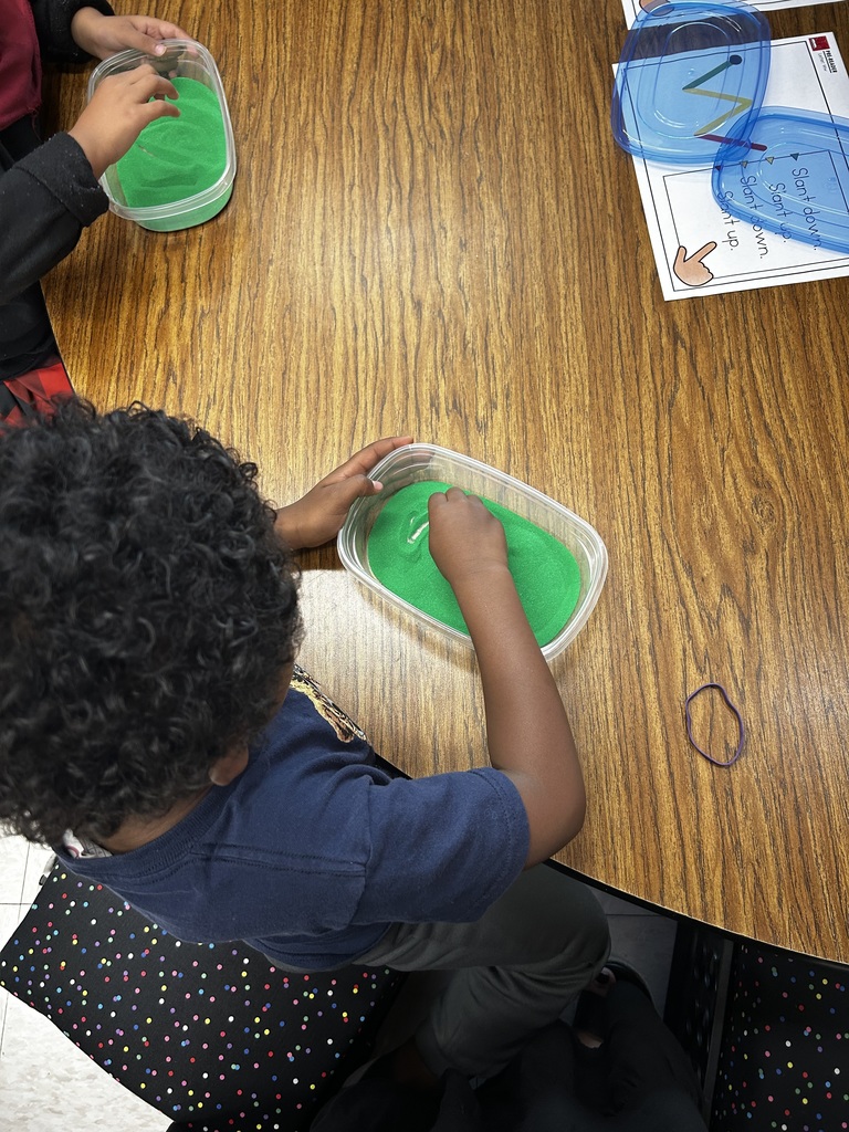 Student plays with green slime in plastic container