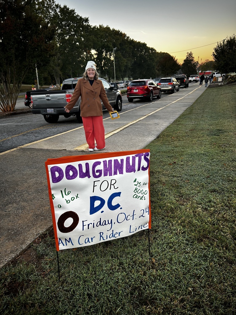 Parent stands behind sign that says "Doughnuts for DC". 