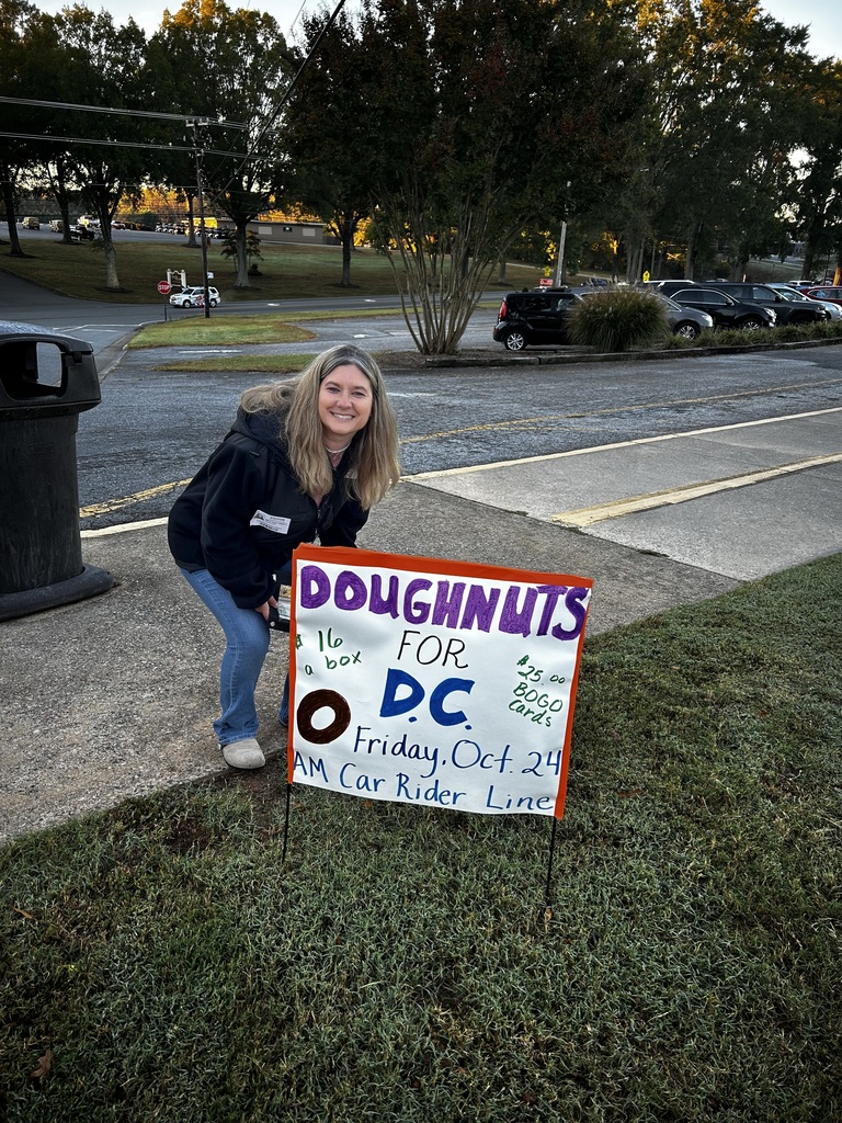 Parent squats down behind "Doughnuts for DC" poster