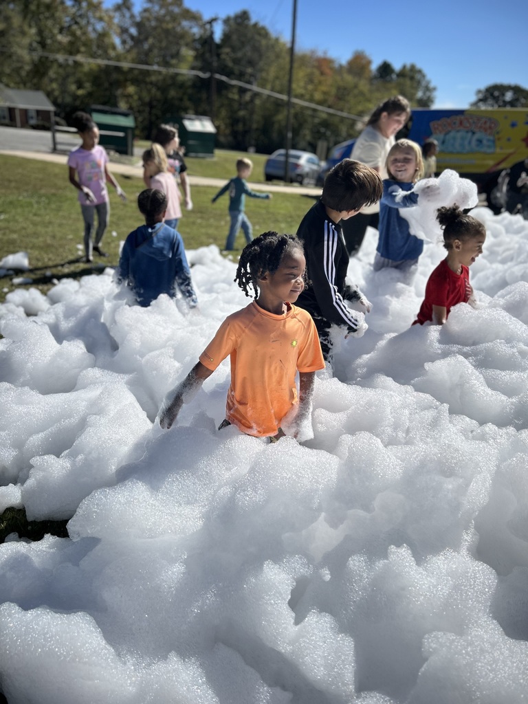 Students stand in pile of foam.