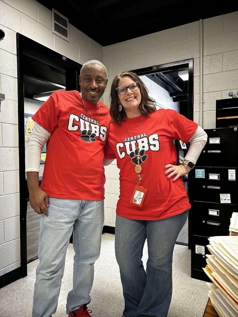 the principal and assistant principal stand wearing jeans and a red "Panther cubs" t-shirt with white long sleeve shirts underneath. 