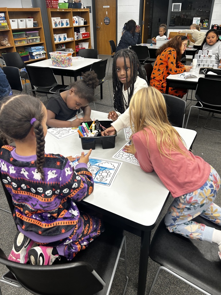 Group of students sit together coloring. 