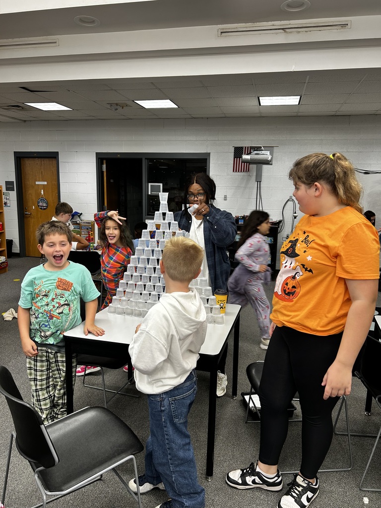 Students build a structure out of cups. 