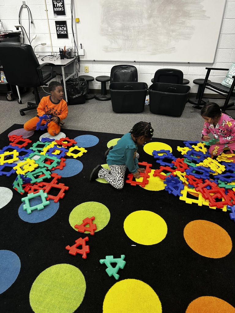 Group of students build structures using giant building blocks.