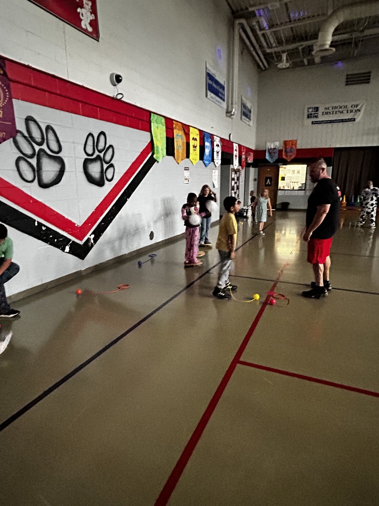 Students play together in gym with PE teacher. 