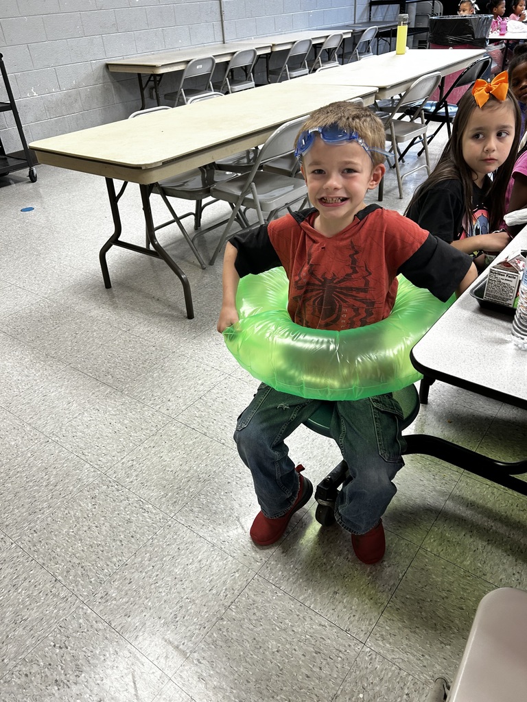 Student wears inflatable tube around waist and goggles on head. 