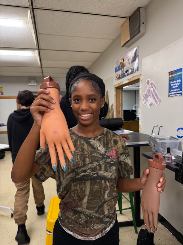 student showing off a nail design in cosmetology & barbering