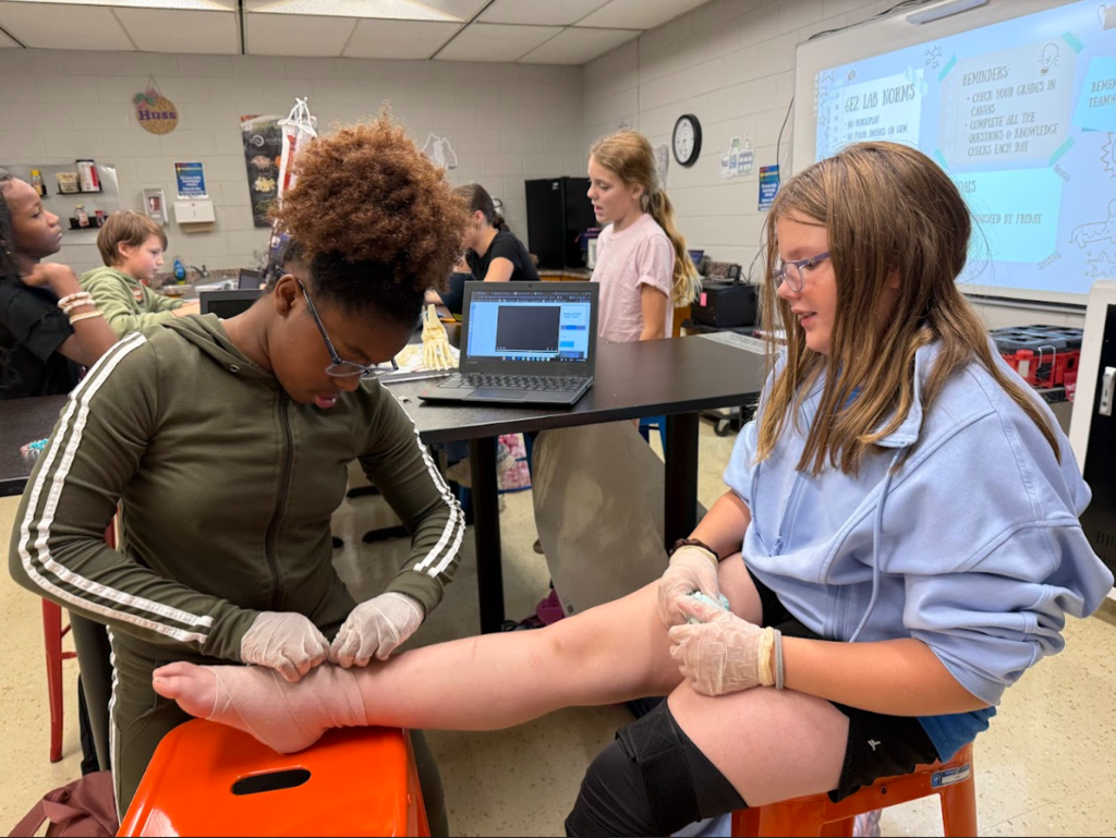 a student wrapping another students ankle in sports medicine