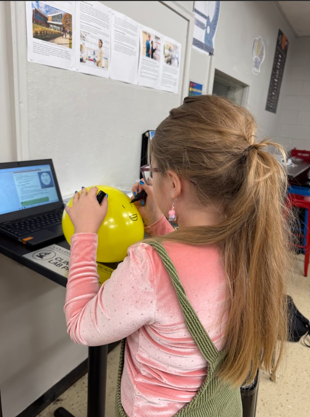 Student drawing hair growth pattern before practicing shaving in cosmetology & barbering