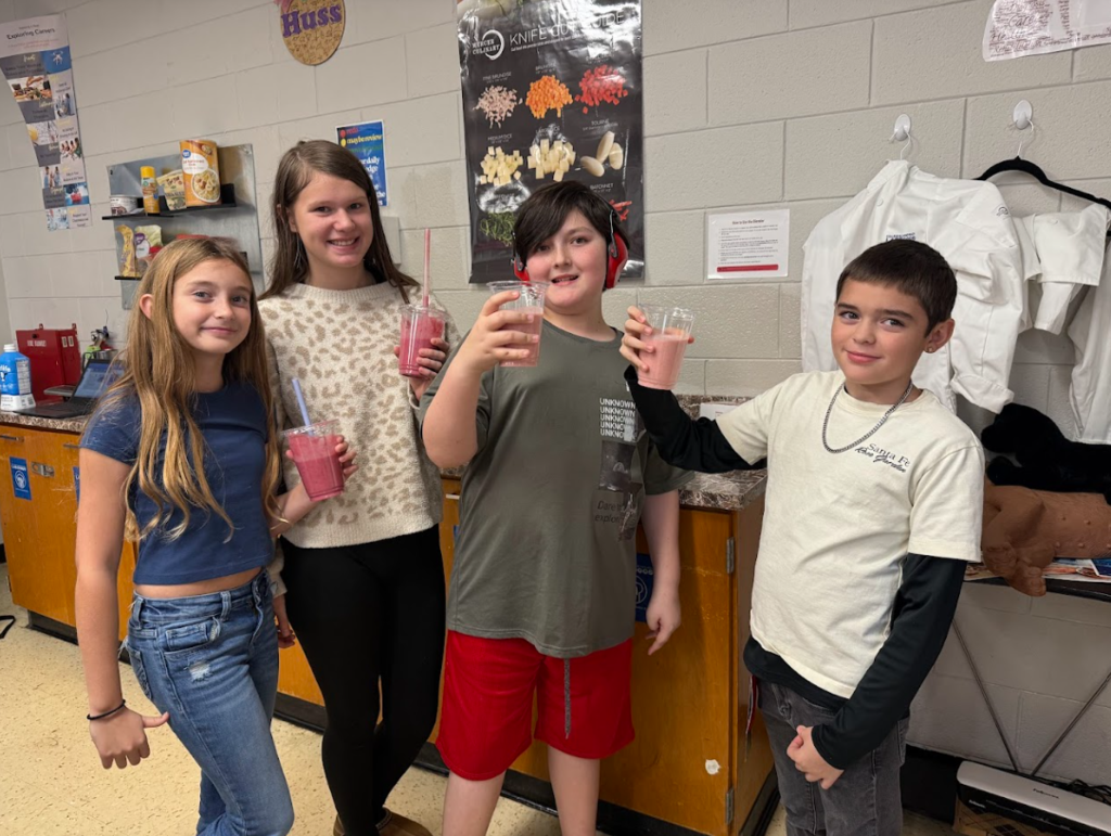 students showing off their smoothies in Intro to Culinary Skills