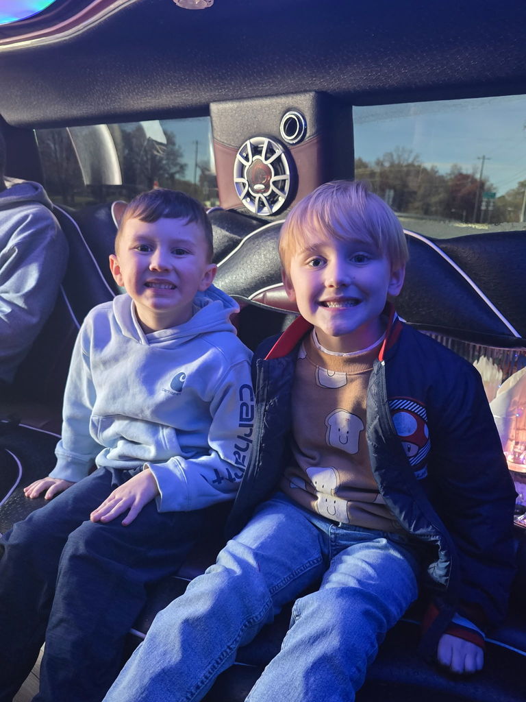 two boys sit together in limo