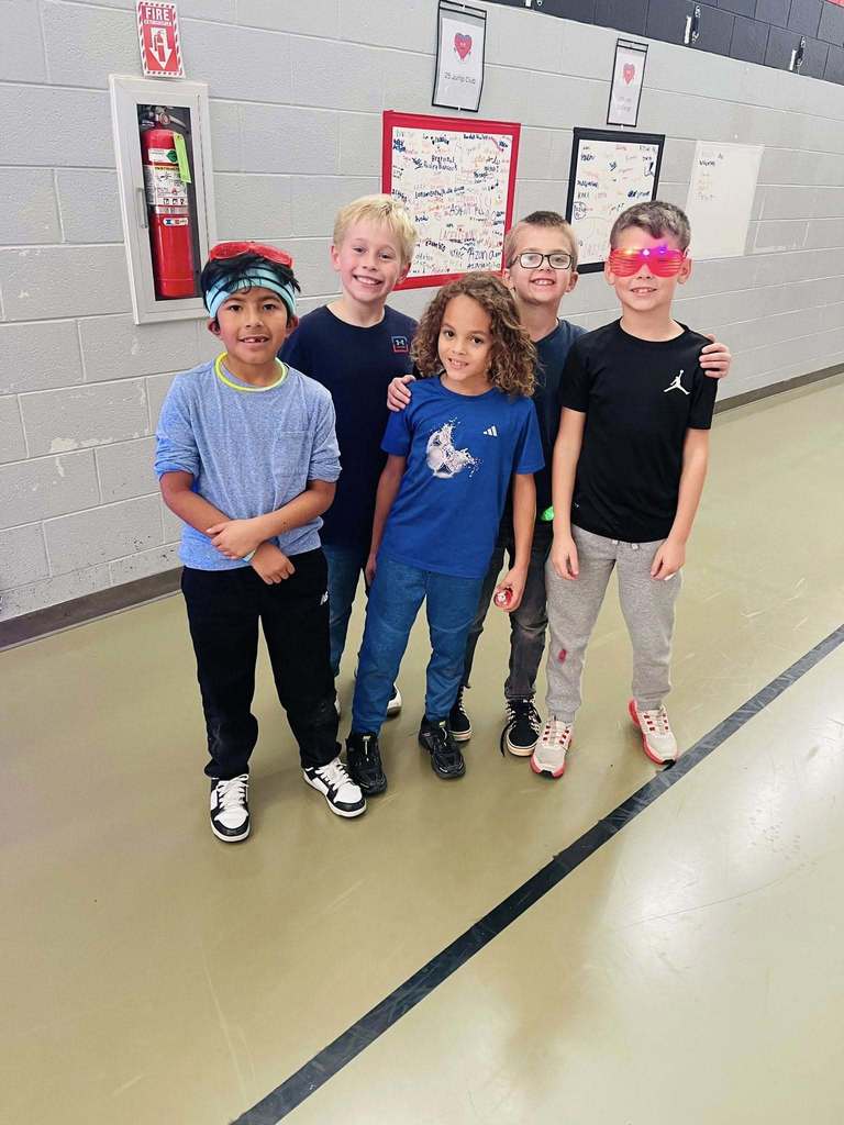 five boys stand together, one wears glow in the dark sunglasses